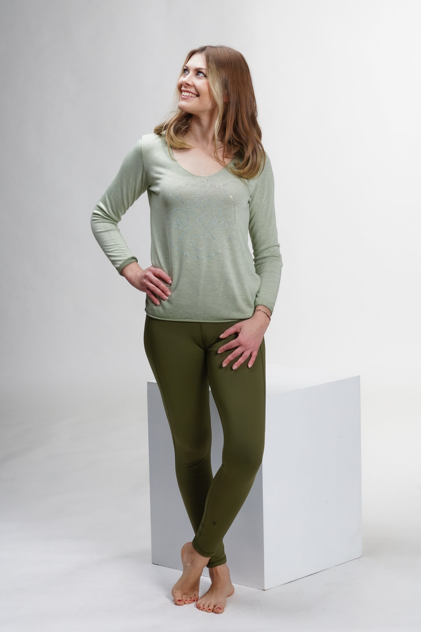 Feinstrick Shirt in hellgrün – kombiniert mit Jeans für einen lässig-eleganten Style mit Yogaflair.
